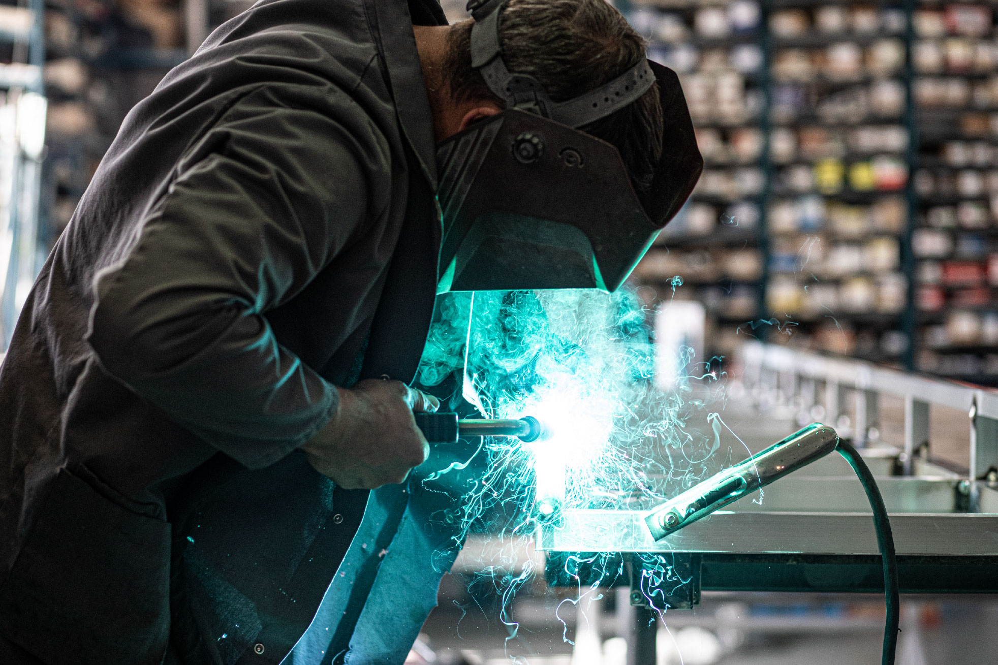 Mitarbeiter beim Schweissen in der Werkstatt bei der Herstellung von Leuchtwerbung