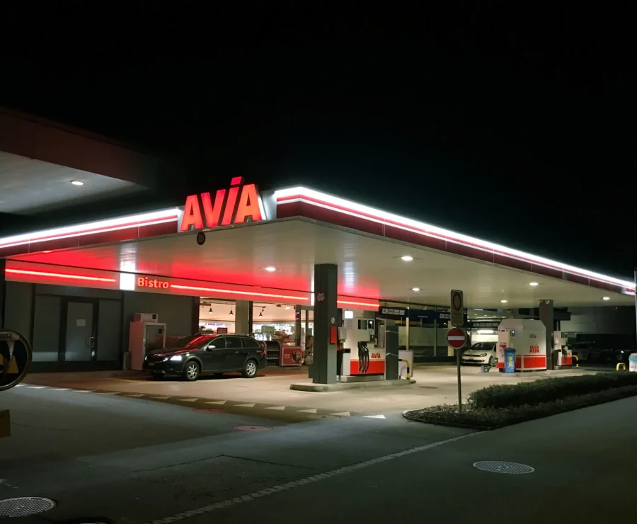 AVIA Tankstelle bei Nacht mit beleuchtetem Bistro und Zapfsäulen